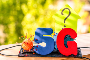 Symbol of coronavirus and 5g networks next to the question mark. The effect of 5g networks on coronavirus
