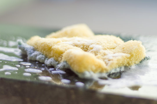 marble surface with cleaning sponge, yellow and green, cleaning to protect against viruses and bacteria