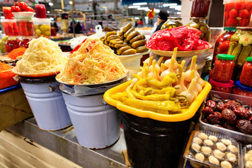Large enamelled buckets of fermented cabbage, peppers, choppers, cucumbers, tomatoes and other vegetables are sold in the market. The concept of vegetarian food.
