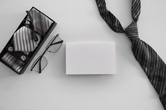 Father's Day inscription with tie and glases, tool kit or wallet, box with a tie and cufflinks with a bow on white  Greetings and presents. white card with the ability to insert text, flatlay