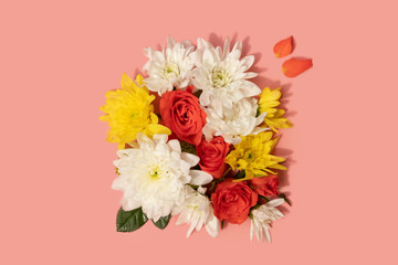 flat lay style bunch of chrysanthemum and roses flowers on pink background