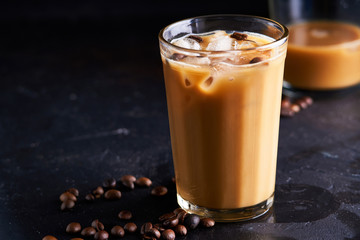 Tasty ice coffee with milk , cold drink in glass on dark background