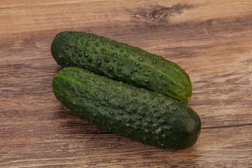 Green fresh cucumbers over background