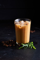 Tasty ice coffee with milk , cold drink in glass on dark background