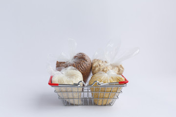 various groats in a grocery basket on a white background