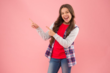 Dont just walk past. Happy girl pointing at pink background. Little kid with pointing gesture. Index fingers pointing. Pointing for advertising. Information for promoting. Gain visibility, copy space