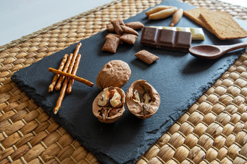 Pan y chocolate sobre plato de pizarra y mantel de mimbre hecho a mano.