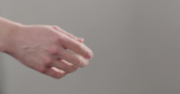 Slow motion man stretches hand for a handshake or help on neutral background
