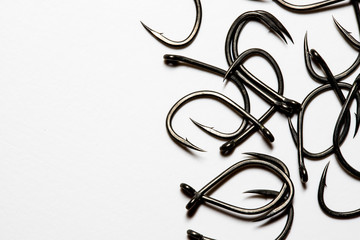 Large, sharp fishing hooks on a white background with copy space for text.