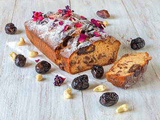 Homemade date and walnut cake on white wooden table