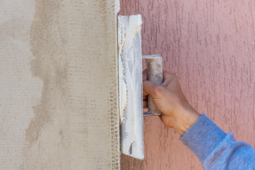 Construction worker plastering cement on wall.