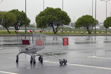 empty grocery basket from the supermarket and its reflection in the rain in the Parking lot © justoomm