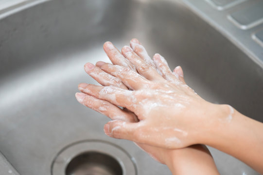 Close up woman hand washing under running water in the kitchen.Hygiene and cleaning Hands.Image hand washing step concept.