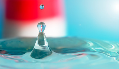 lighthouse in drop of water over the blue surface of the water