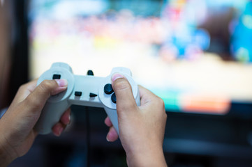 Selective focus gamer hand playing video game  at home.A boy enjoy and relax with game online on TV.Stay at home concept.