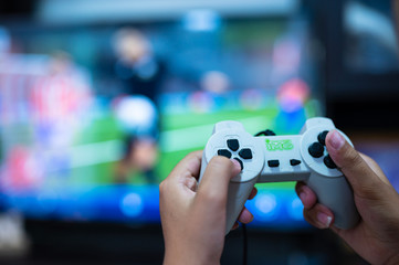 Selective focus gamer hand playing video game  at home.A boy enjoy and relax with game online on TV.Stay at home concept.