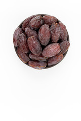 Dried dates in round bowl on white background, top view
