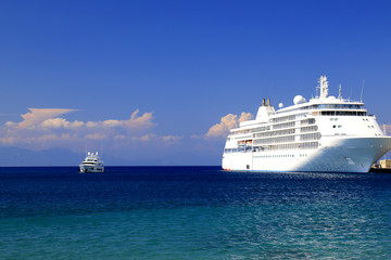 Fototapeta na wymiar Sea background. A large white passenger cruise ship stands at the tourist seaport, Rhodes, Greece. Liner, water transport for travel, recreation. Sea, ocean landscape, spring, summer vacation.