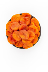 Dried apricots in round bowl on white background, top view