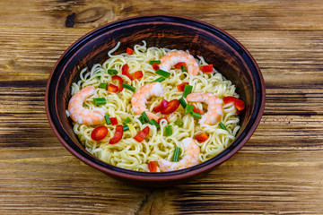 Instant noodle with shrimps, red pepper and green onion in a ceramic bowl. Japanese food