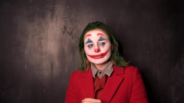 Person in Joker cosplay standing over black background