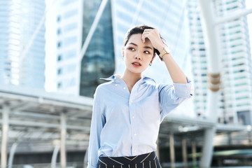A beautiful Asian business woman is walking in a business district.