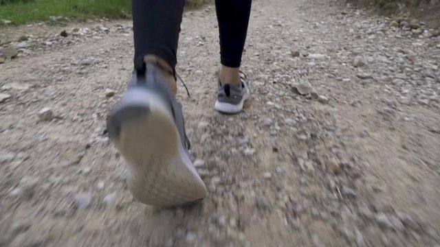 Plano detalle de seguimiento de una chica corriendo por la monta&ntilde;a en un d&iacute;a nublado.
