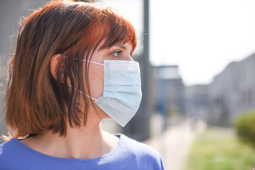 The red-haired girl in the surgical mask with the sad look