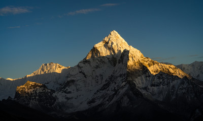 Colourful Amadablam mountain peak, known as the mother of mountains, glowing in warm sunlight...