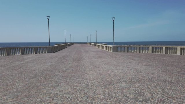 Rome at  lockdown time view pan left of pier on the beach in Roman coastline , usually a tourist landmark