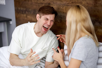 husband and wife do not understand each other, argue lying on bed, scream and try to explain and discuss problems with each other, but they can't do it