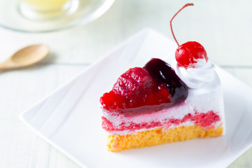 Close up Sliced mix berry cake with blur Hot ginger drink background