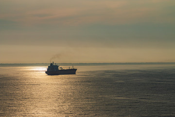 Cargo ship in the ocean. Ship at sunset.