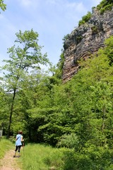 Una ragazza cammina in una valle ai piedi di una parete rocciosa