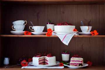 Cakes with red currant decorated with fresh red berries and flowers