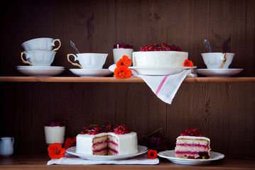 Cakes with red currant decorated with fresh red berries and flowers