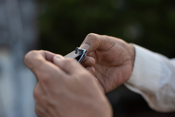 man cutting his nails by a nail cutter on rooftop outdoor. Covid, Lock down and Home isolation
