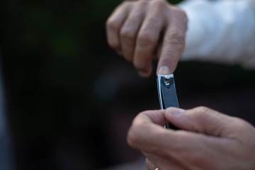 man cutting his nails by a nail cutter on rooftop outdoor. Covid, Lock down and Home isolation