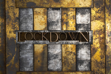 Photo of real authentic typeset letters forming Lockdown text on vintage textured grunge copper and black background 