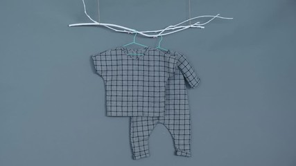 Baby clothes. Gray pants and a shirt on a gray background.