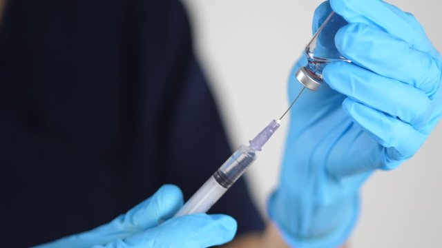 Doctor, nurse, scientist, researcher hand gloves holding flu, measles, coronavirus, covid-19 vaccine disease preparing for human clinical trials vaccination shot, medicine and drug concept.