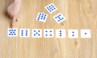 The child lays out cards with dots according to the number of dots. Learning numbers and math.