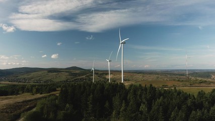 Camera flight over landscape with power plant. Aerial view to wind turbine. Sustainable electricity solution. Windmill near small village in western Ukraine