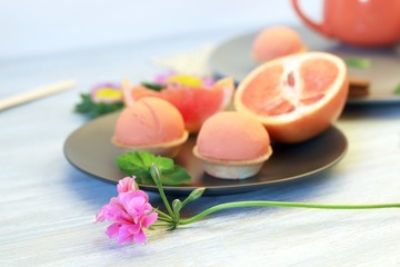 Natural ice cream, sorbet, grapefruit, mint, flowers on a wooden table, tasty and healthy dessert, seasonal food