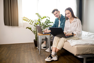 young and beautiful caucasian couple use laptop, work at home, man and woman busy with their own business. couple at freelance work
