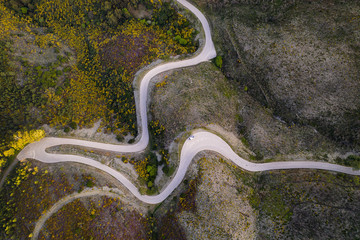 Beautiful drone aerial top view of road with curves in mountain landscape with a van social distancing near Piodao, Serra da Estrela in Portugal