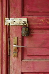 Bright but old wooden door with gorgeous owl lock at it. The entrance door closed with a cute lock.