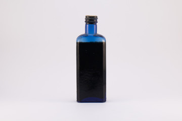 Old blue and black glass bottle on a white background