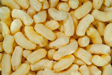 Texture of yellow crispy corn sticks. Lots of corn chips close up.