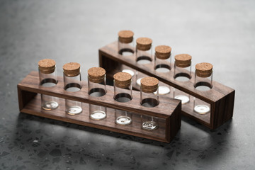 empty walnut holder with glass tubes for spices on concrete surface